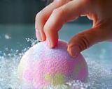 User dropping colorful bath bomb into water